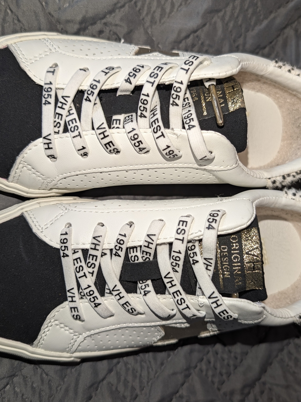 White and Black Low-Top Sneakers with Gold Tongue Label